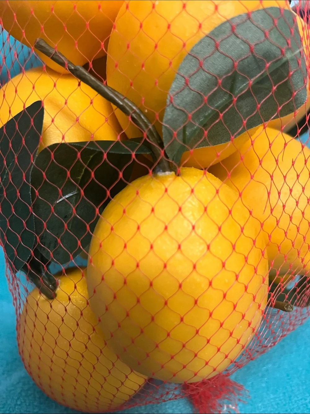 Kirklands Yellow Faux Lemons with Green Leaves in Red Mesh Bag